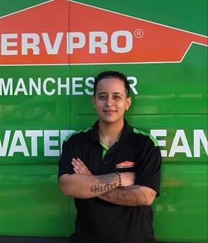 Women Employee with dark hair pulled back in front of a SERVPRO Truck