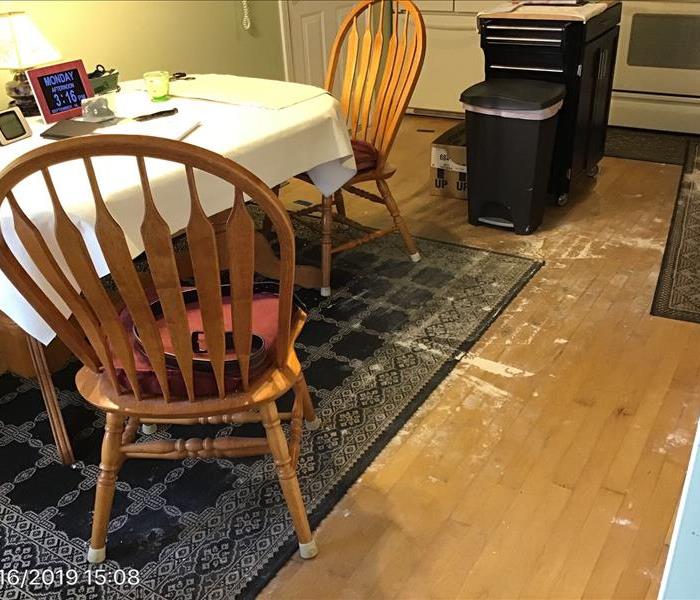 water damaged kitchen with buckled wood floor and sagging ceiling.